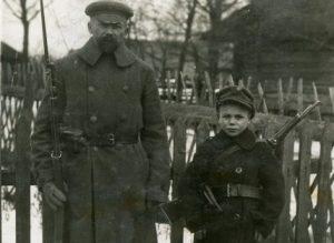 Nuotraukoje ūkininkas Kalaida su sūnumi apsiginklavę rusišku šautuvu „Mosin-Nagant” ir karabinu, pasiruošę gintis nuo bermontininkų. Smilgiai, Panevėžio apskritis. 1919 m. | Vytauto Didžiojo karo muziejaus archyvo nuotr.