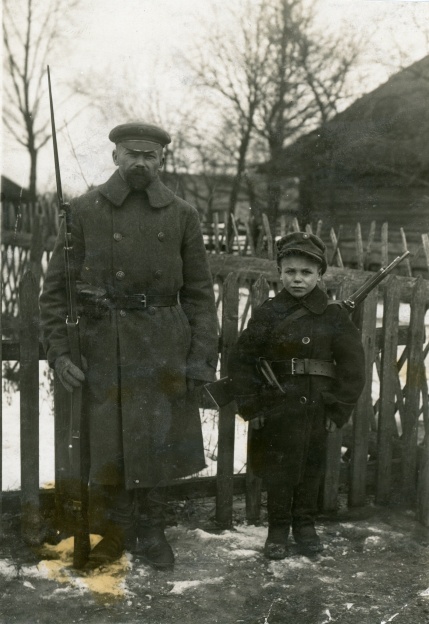 Nuotraukoje ūkininkas Kalaida su sūnumi apsiginklavę rusišku šautuvu „Mosin-Nagant” ir karabinu, pasiruošę gintis nuo bermontininkų. Smilgiai, Panevėžio apskritis. 1919 m. | Vytauto Didžiojo karo muziejaus archyvo nuotr.