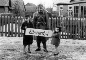 3-iosios brigados kuopos vadas Bury su vietiniais vaikais laiko kelio nuorodą į kpt. J. V. Eibergo sodybą Asciukiškių dvare. J. V. Eibergas buvo visų AK derybų su vokiečiais dalyvis | „Voruta“ nuotr.