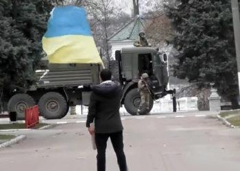 Su vėliava prieš ginkluotus okupantus | Alkas.lt ekrano nuotr.