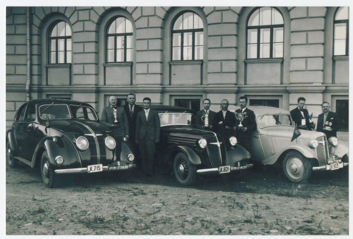1938 m. liepos mėn. 23-24 d. vykusio automobilių ralio „Aplink Lietuvą“ prizininkai: 4 vietos laimėtojai, 1 vietos laimėtojais M. Salevskis su Prezidento A. Smetonos įsteigtu prizu – dekoratyviu bokalu, Matulaitis ir Juchnevičius šalia „Adler“ markės automobilio. 2 vietos laimėtojai: Mykolas Ratomskis su prizu rankoje ir Januška | Istorinės Lietuvos Respublikos Prezidentūros Kaune archyvo nuotr.
