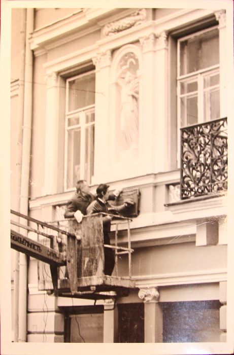 Filibertas Tamoševičius su kolega tvirtina beveik 100 kg sveriančią memorialinę lentą prie Signatarų namų, toje pat vietoje, kur kabojo ankstesnė. Meistrai surado tas pačias senąsias skyles, į kurias sukalti metaliniai tvirtinimo elementai | Asmeninio F. Tamoševičiaus archyvo nuotr.