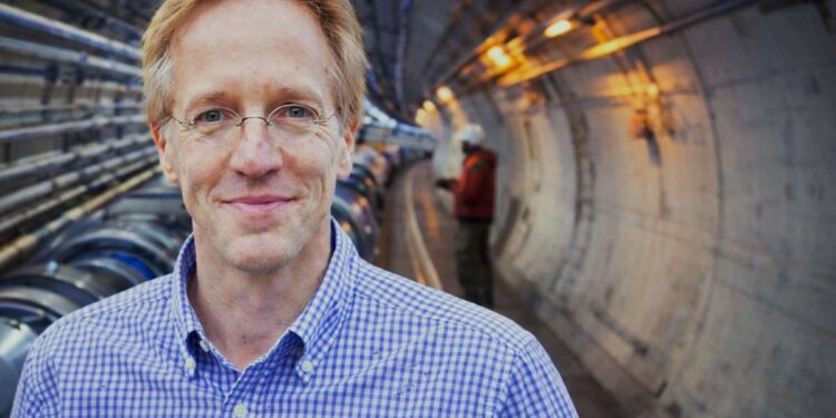 Robertas Deikgrafas o jam už nugaros dalelių greitintuvo tunelio siluetas