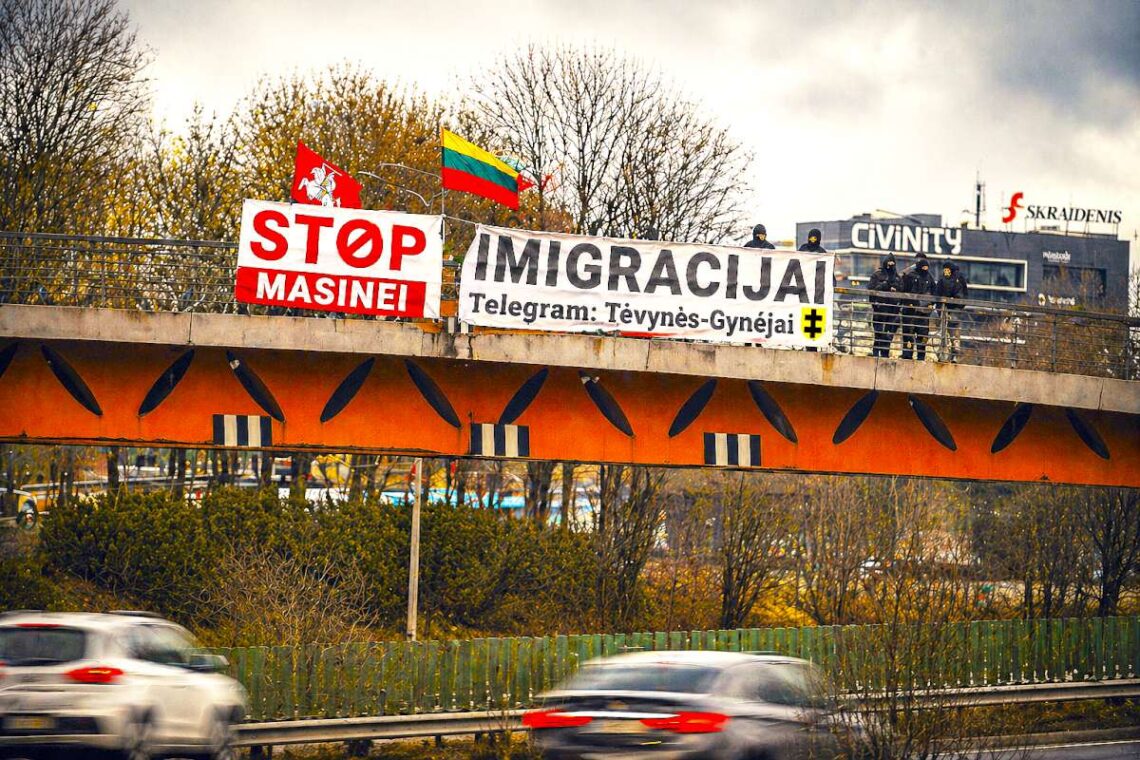 Ant tilto plakatas „STOP masinei imigracijai“