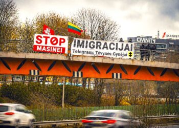 Ant tilto plakatas „STOP masinei imigracijai“