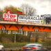 Ant tilto plakatas „STOP masinei imigracijai“