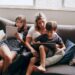 Mama su vaikais sėdi ant sofos ir naudojasi 5g namų internetu
