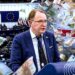 Dainius Žalimas Europos Parlamente, koliaže pavaizduoti byrantys eurai ir Baltarusijos opozicijos vėliavos spalvos