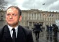 S. Buškevičius prie Krašto apsaugos ministerijos pastato niūriame karinės įtampos fone