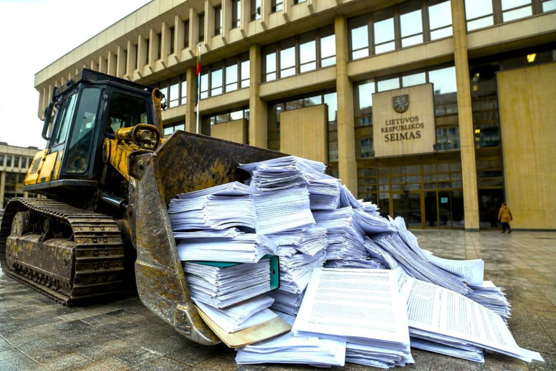 Buldozeris stumia dokumentų krūvą prie Lietuvos Respublikos Seimo