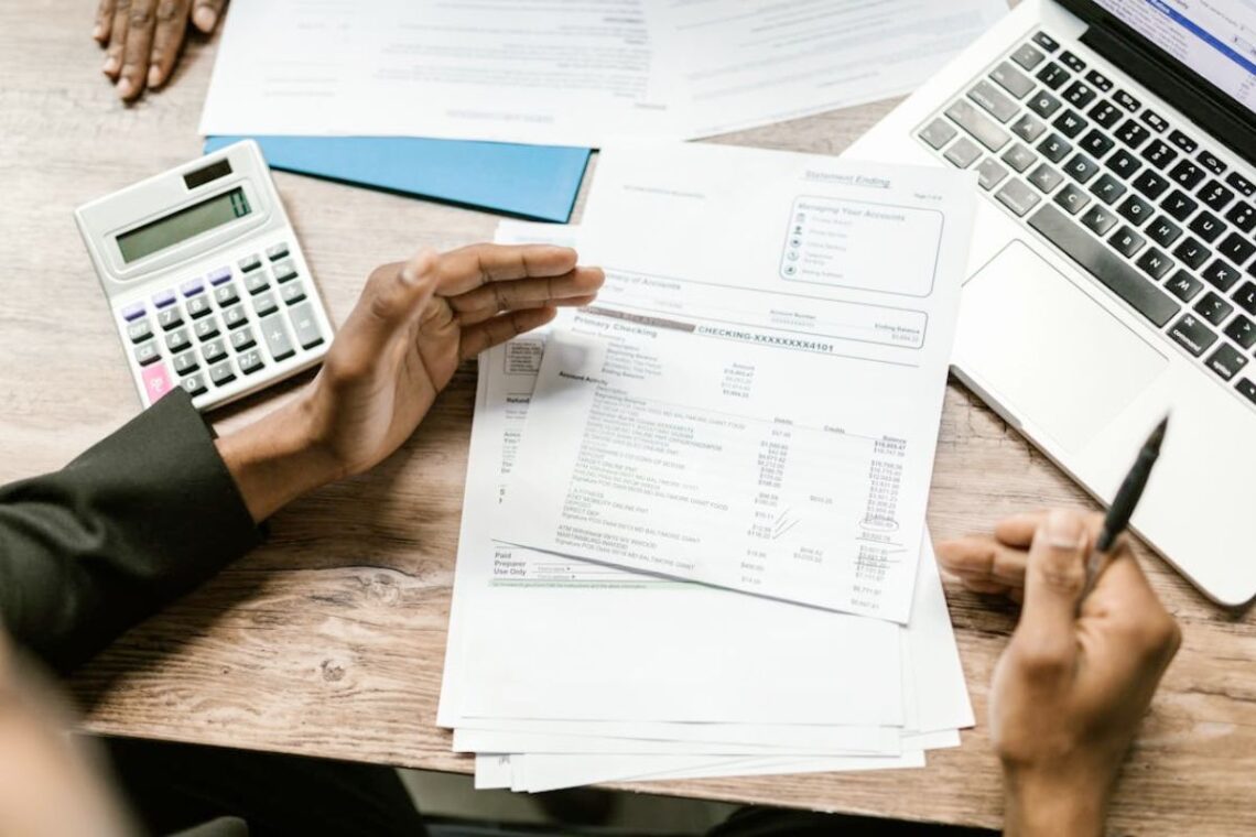 Verslo finansų dokumentai, skaičiuotuvas ir nešiojamasis kompiuteris