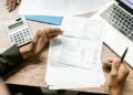 Verslo finansų dokumentai, skaičiuotuvas ir nešiojamasis kompiuteris
