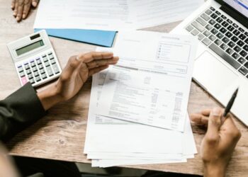 Verslo finansų dokumentai, skaičiuotuvas ir nešiojamasis kompiuteris