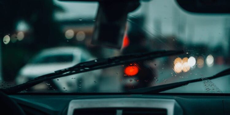 Automobilio priekinis stiklas lietingą dieną. Net ir nedidelė įdauža gali tapti dideliu skilimu, jei laiku nesuremontuojama