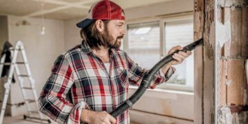 Žmogus siurbia statybines dulkes Karcher dulkių siurbliu