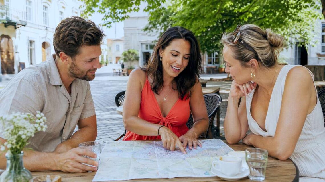 Trys bičiuliai vasaros kavinėje aptaria kelionės planą