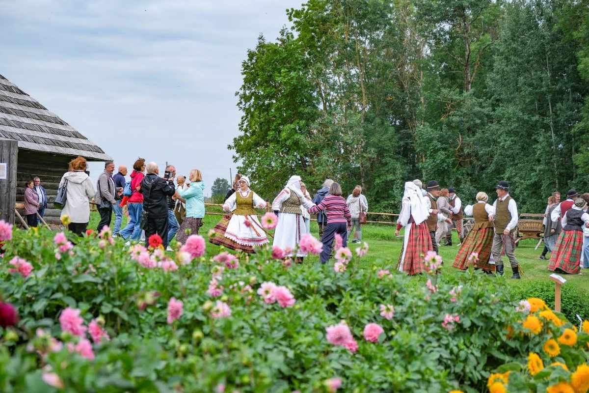 Kleboniškių muziejaus lankytojai ir folkloro ansamblio „Rags“ nariai šoka lauke
