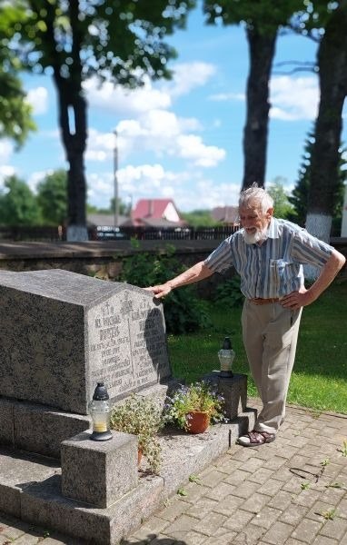 Vytautas Liudas Dailidka prie kunigo M. Rudzio kapo Kalesninkų bažnyčios šventoriuje
