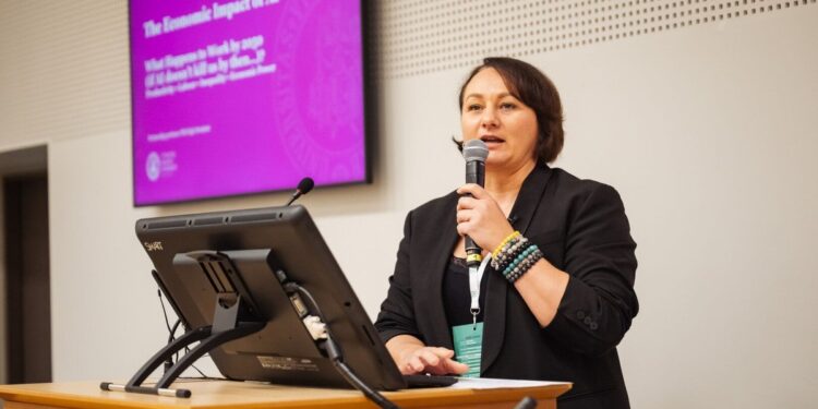 VDU docentė dr. Eglė Stonkutė skaito pranešimą apie dirbtinio intelekto ekonominį poveikį