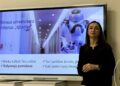 Dr. Gražina Korvel prie ekrano, kuriame pristatomas Vilniaus universiteto robotas „Ąžuolas“