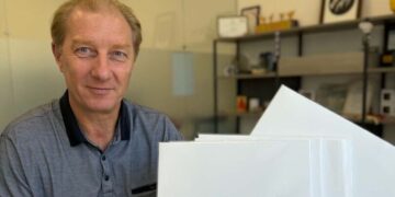 Vyras su vinilinės plokštelės „Dainuojam Justiną Marcinkevičių“ egzemplioriais