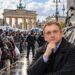 Stanislovo Buškevičiaus portretas migrantų eilės ir Europos alegorijos fone