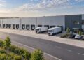 Modernus logistikos centras su sandėliais ir sunkvežimiais prie pakrovimo rampų