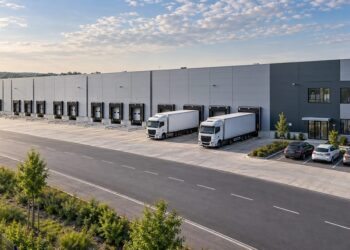 Modernus logistikos centras su sandėliais ir sunkvežimiais prie pakrovimo rampų