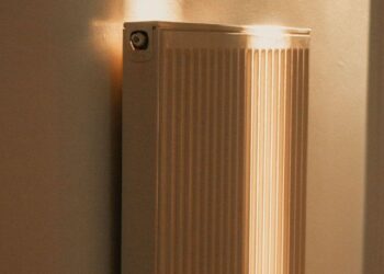 Saulės apšviestas radiatorius namų kambaryje
