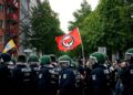 Policijos pareigūnai ir „Antifa“ vėliava 2014 m. gegužės 1-osios demonstracijoje Berlyne