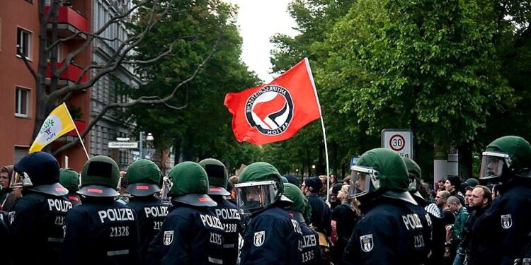 Policijos pareigūnai ir „Antifa“ vėliava 2014 m. gegužės 1-osios demonstracijoje Berlyne