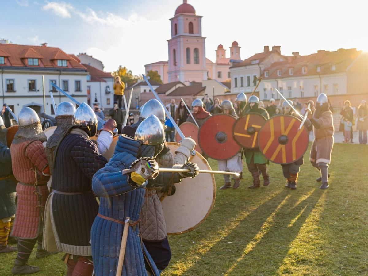 Dvi viduramžių karių grupės su skydais ir ginklais prieš kovą Vilniaus Bastėjoje