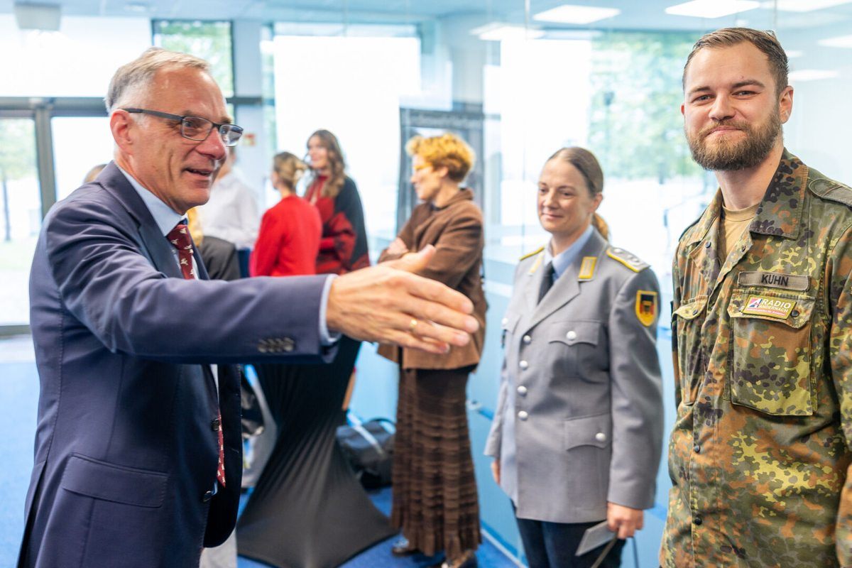 Vokietijos ambasadorius bendrauja su Vokietijos brigados kariais.
