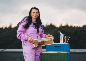Salomėja Mikolajevičienė laiko medaus korį prie avilio