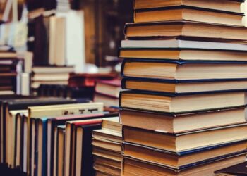 Bibliotekoje ant stalo sukrautos įvairios knygos