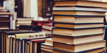 Bibliotekoje ant stalo sukrautos įvairios knygos