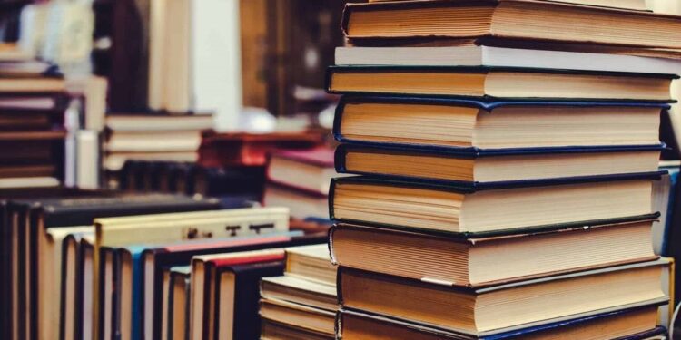 Bibliotekoje ant stalo sukrautos įvairios knygos