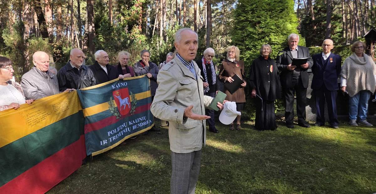 Minėjimo dalyviai prie politinių kalinių ir tremtinių bendrijos vėliavos