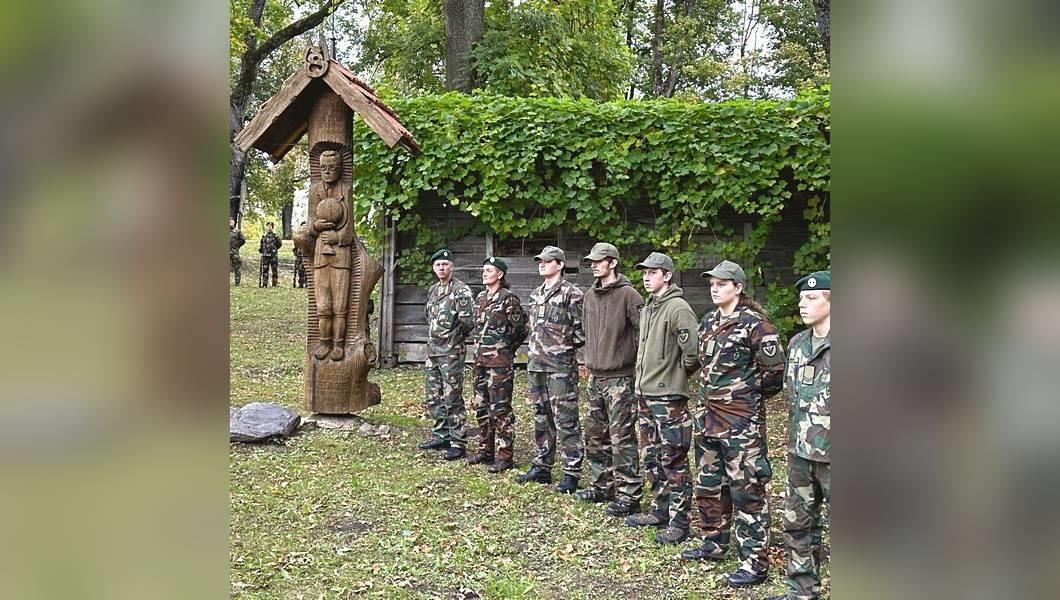 Šauliai išsirikiavę šalia medinės skulptūros Mato Šalčiaus tėviškėje