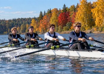 2026 m. spalio 18-osios horoskopo iliustracija – keturi irkluotojai rudeniškame Lietuvos ežere