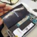 Meistras ardo išmanųjį telefoną ir tikrina jo vidines dalis
